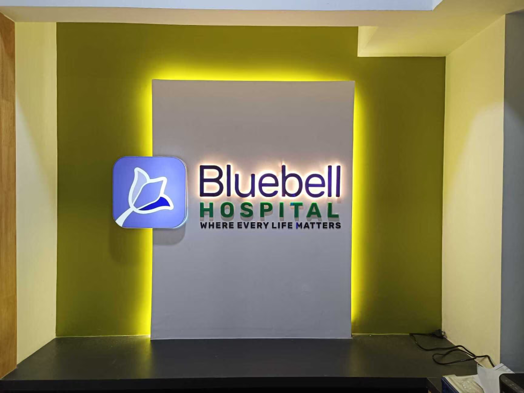 Bluebell Hospital main reception area showcasing the custom periwinkle, green, and deep indigo brand signage