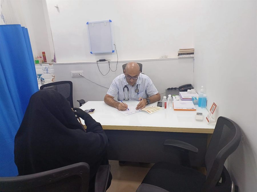Doctor consulting a visitor across a desk at a health camp