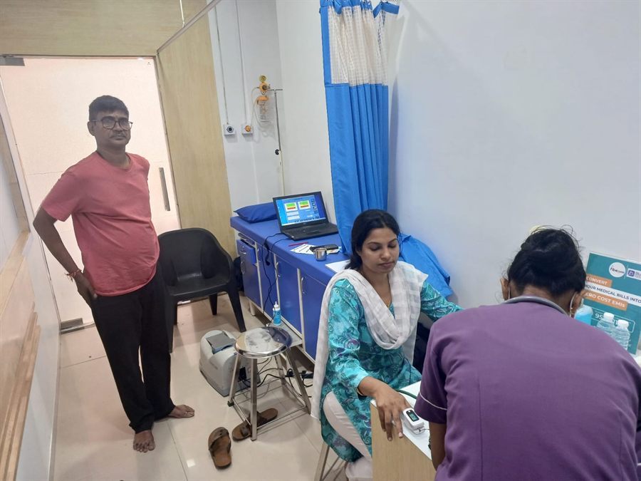 Visitor being screened beside diagnostic equipment