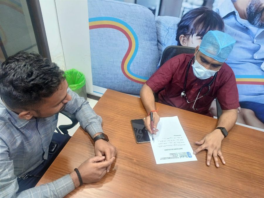 Doctor going through paperwork with a visitor at a consultation table