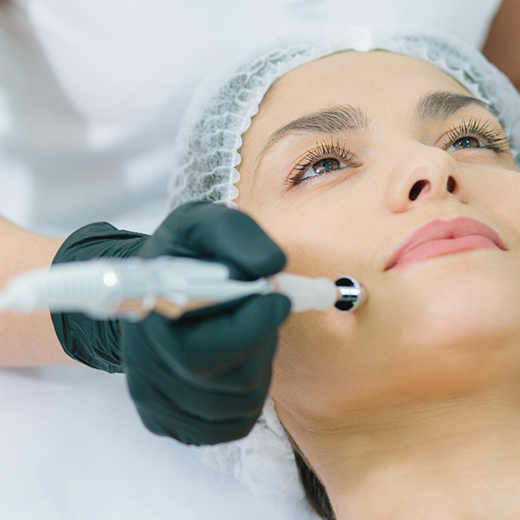 Patient receiving a skin treatment with a handheld dermatology device