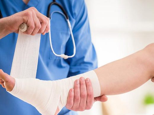 Nurse bandaging a patient's foot at Bluebell Hospital